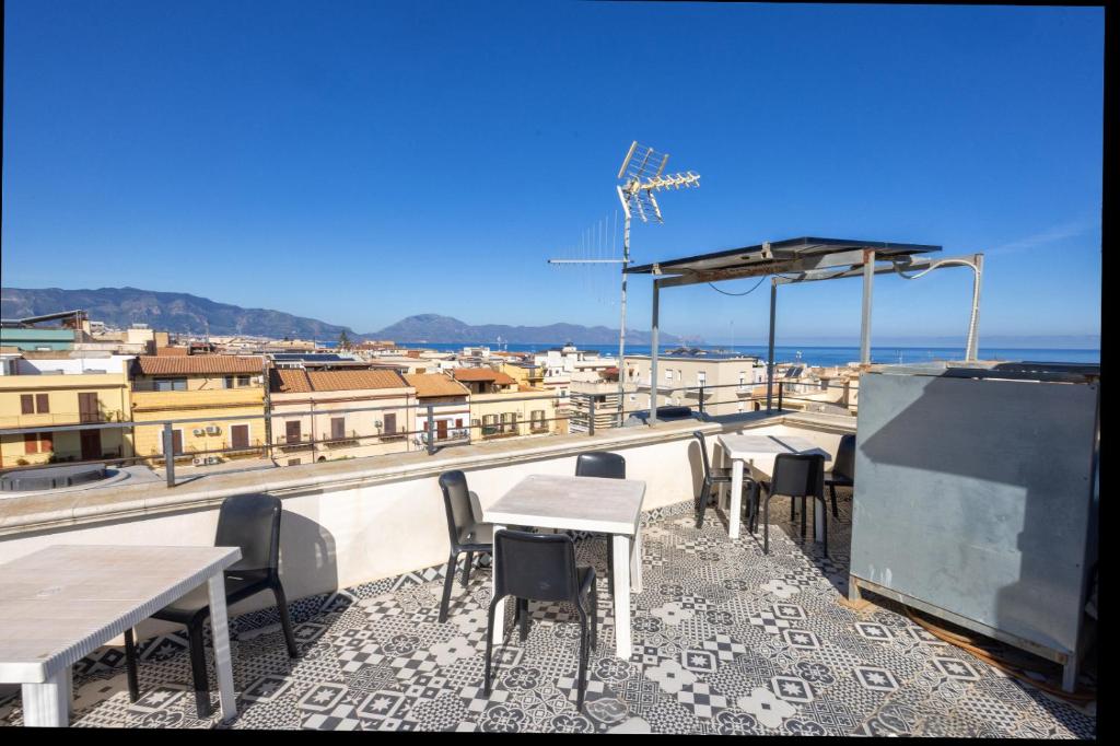 a patio with tables and chairs on top of a building at Disiu Case Vacanza in Balestrate