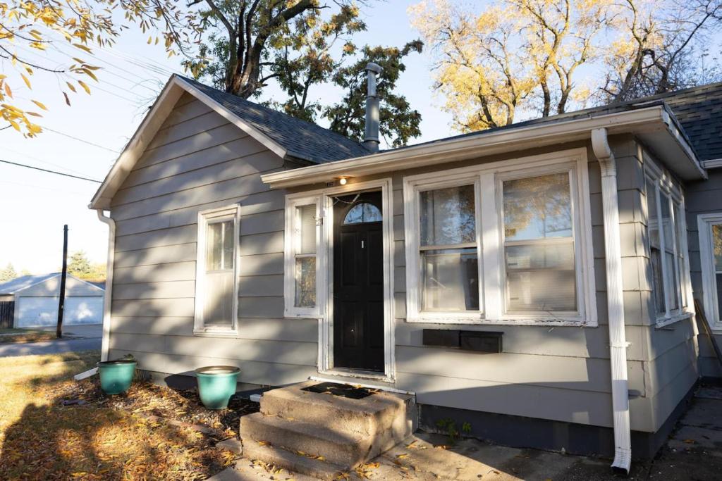 Cette petite maison blanche dispose d'une porte et de fenêtres. dans l'établissement Sunshine Cottage 2 bedroom in duplex, à Hastings