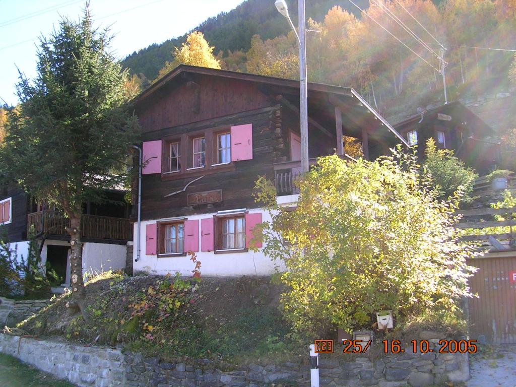 una casa con pintura rosa en el costado. en Chalet Edith Oberems en Oberems