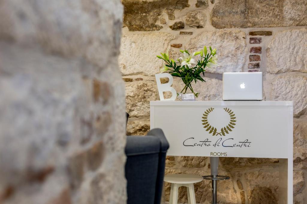 a table with a laptop on it next to a wall at Centro di Centri Rooms in Split