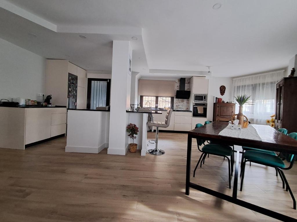 a living room with a table and a kitchen at El Rincon La Roca in El Espinar