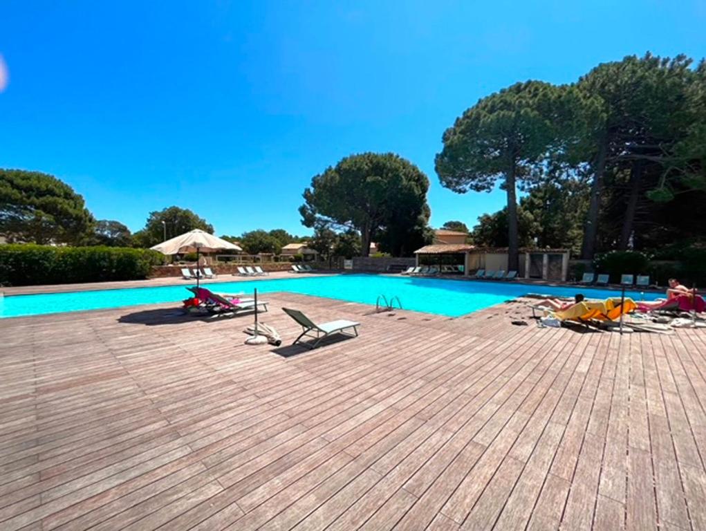 une piscine avec des chaises longues et une piscine dans l'établissement T4 Fior di Cala Rossa by Pinarello Villa Services, à Lecci