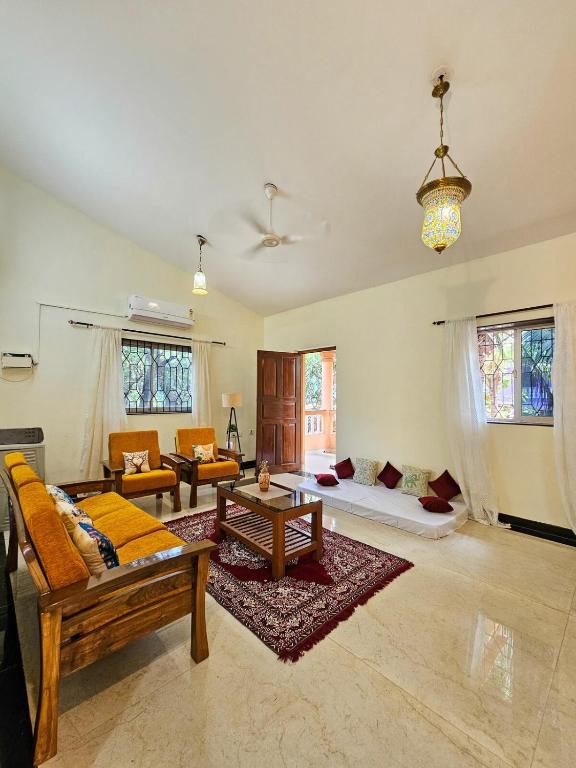 a living room with a couch and a table at Goan Villa,2BHK, 4Balconies, Beachside,BBQ, Wi-Fi,Work, Group in Candolim