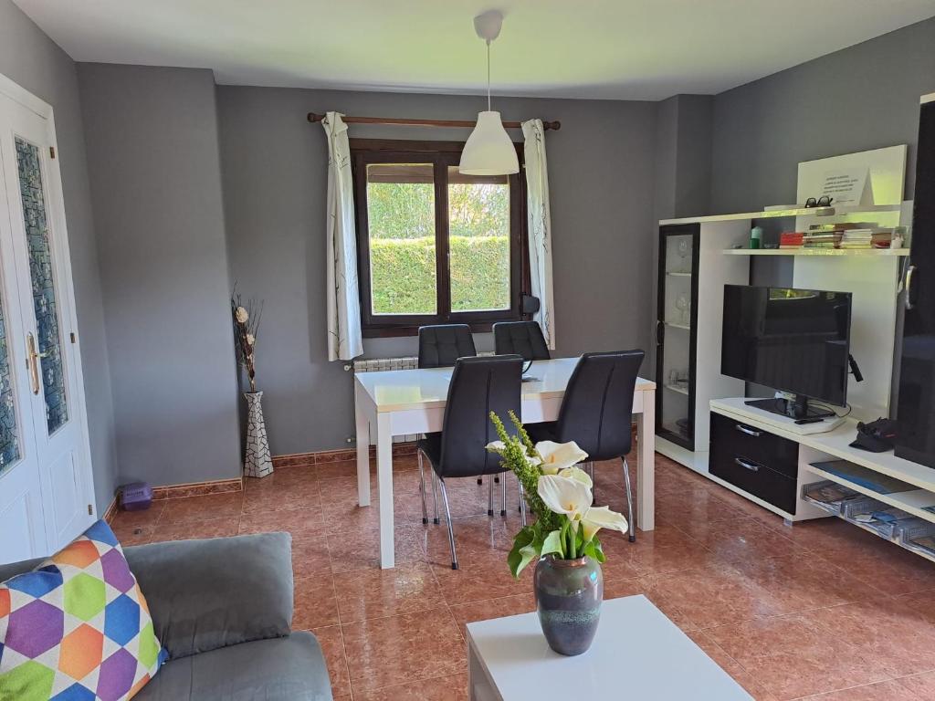 salon ze stołem z krzesłami i telewizorem w obiekcie Meraki House 92B w mieście Arnuero