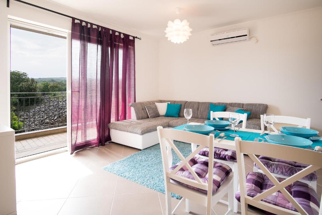 uma sala de estar com uma mesa de jantar e um sofá em Apartment Soni A4 em Krk