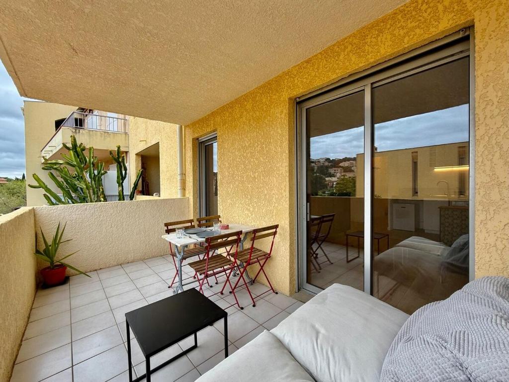 d'un balcon avec un canapé et une table sur la terrasse. dans l'établissement Central - Terrasse - Vue montagne, à Carqueiranne