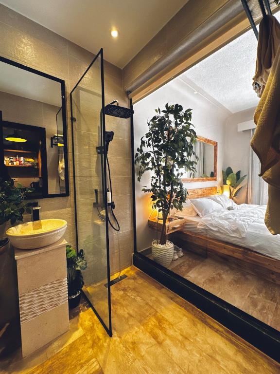 ein Badezimmer mit Dusche und Waschbecken und ein Bett in der Unterkunft Yari serenity spot in Raʼs Matarma