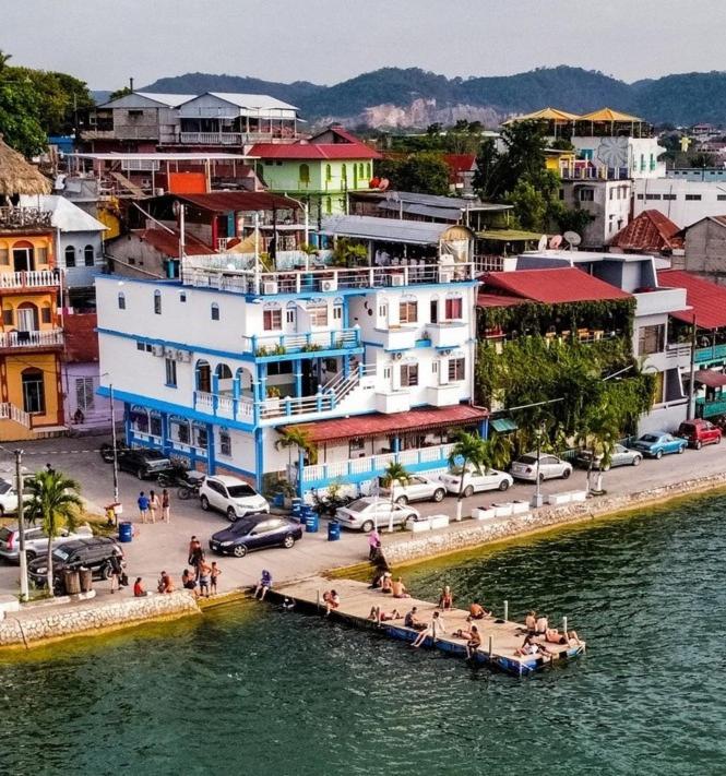 un grupo de personas sentadas en un muelle en una ciudad en Hotel La Union, en Flores