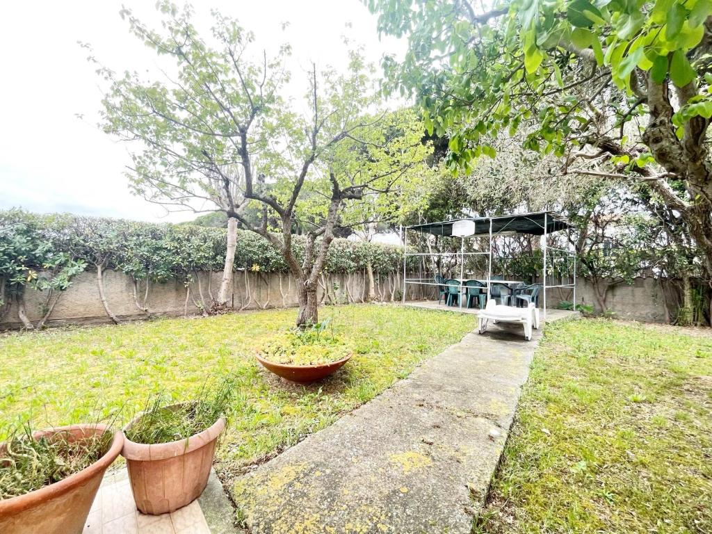 een tuin met een tafel en enkele planten in een tuin bij Casa Berso' a Marina di Cecina by Zoom In Earth in Marina di Cecina