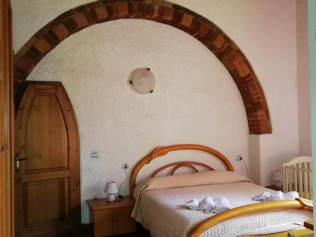 a bedroom with a bed and an arched doorway at I Cavalleggeri in Donoratico