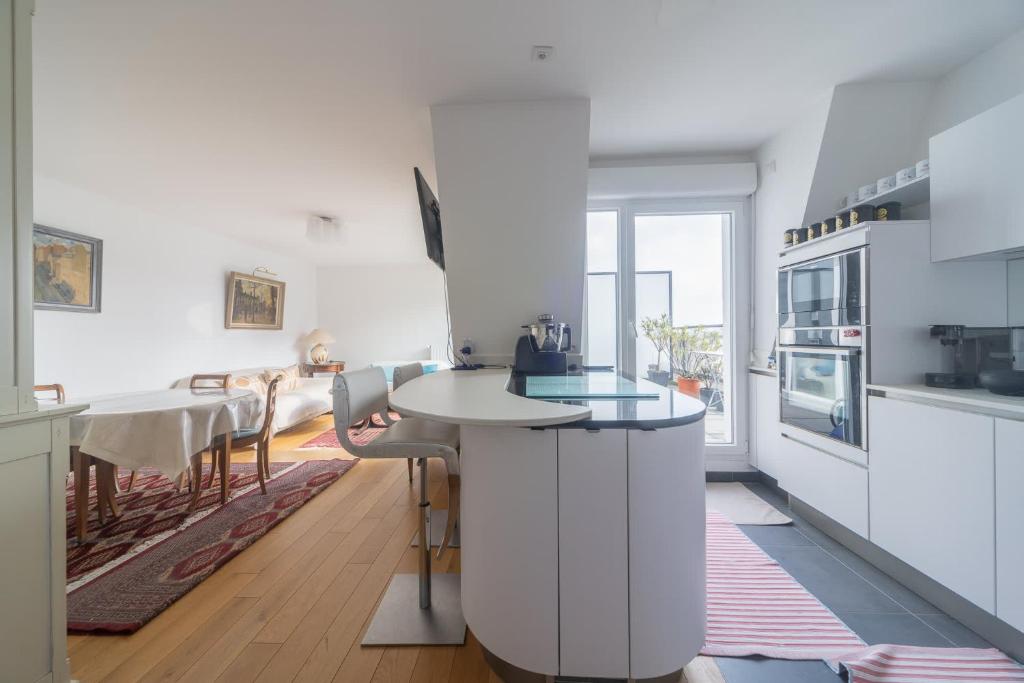 une cuisine blanche avec un comptoir et une table dans l'établissement Terrace - Private Parking - Subway 2 min, à Maisons-Alfort