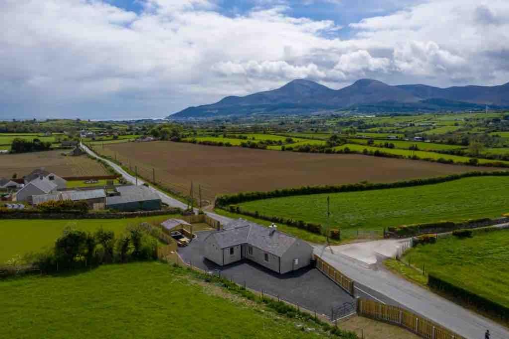 einen Luftblick auf einen Bauernhof mit Bergen im Hintergrund in der Unterkunft Roddys cottage three bedroom with hot tub sleeps6 in Magherasaul