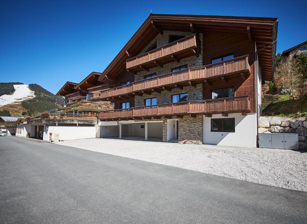 a building with a balcony on the side of a road at Life & Luxury Appartements in Saalbach-Hinterglemm