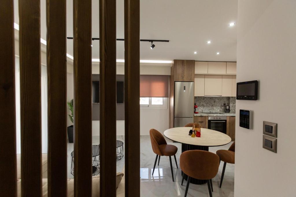 a kitchen and dining room with a table and chairs at BEQUEST Luxury Suites in Korinthos