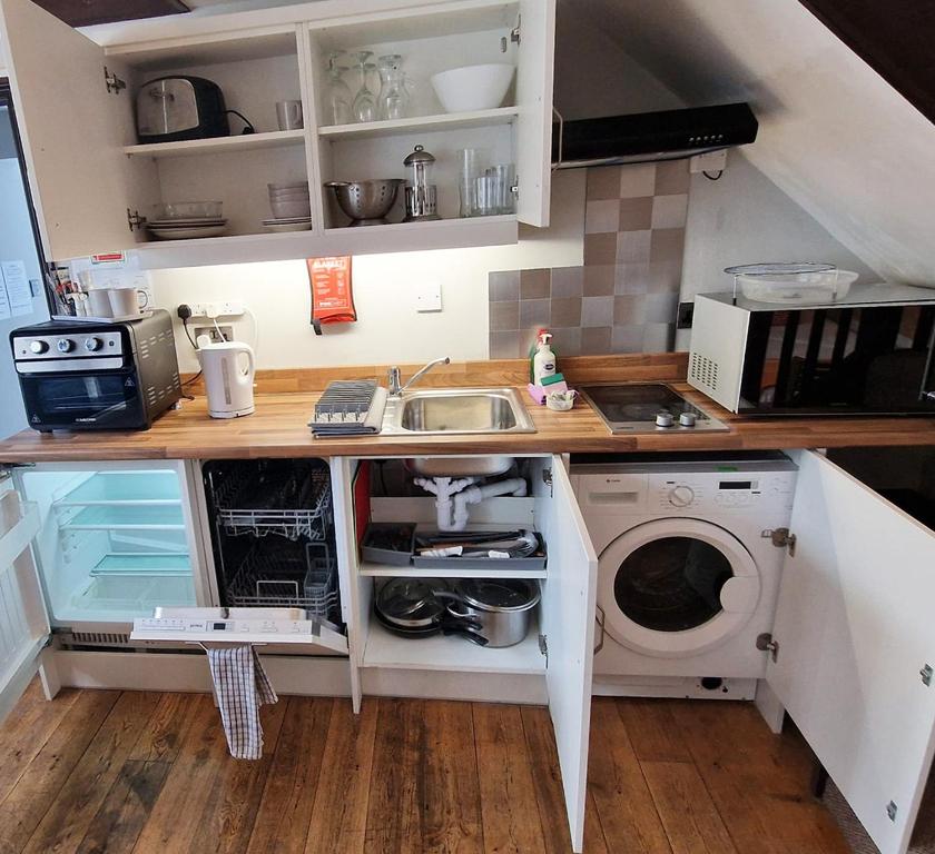 a kitchen with a sink and a washing machine at City Center Ground Floor Flat With Patio &parking in Norwich