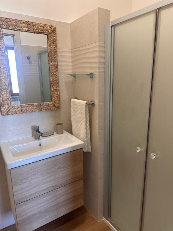 ein Badezimmer mit Waschbecken und Spiegel in der Unterkunft Belvedere Rooms con Piscina - Le Grotte Rooms And Apartments in Camerano
