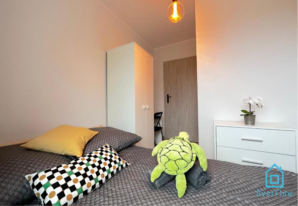 a bedroom with a bed with a stuffed turtle on it at Turtle Room - 3 km to Baltic Sea in Gdańsk