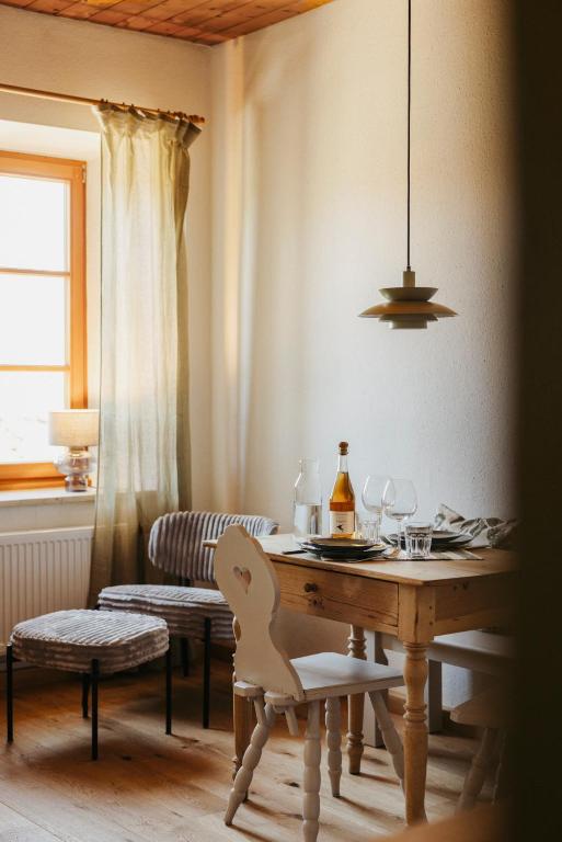 a dining room with a table with a bottle of wine at Staudingerhof in Staudach-Egerndach