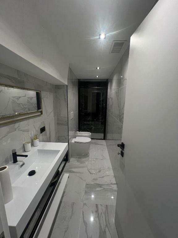 a white bathroom with a sink and a toilet at Vale House Apartment near Rho Fair in Baranzate
