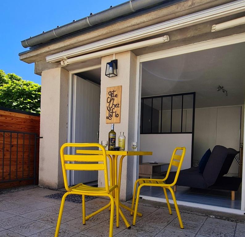 une table jaune et deux chaises sur une terrasse dans l'établissement Gîte Chez Laflo, à Lacapelle-Marival