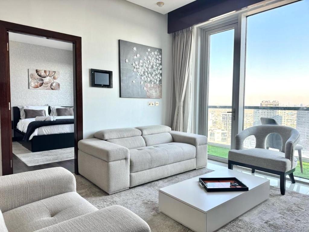 Hotel 3BR Penthouse - 5 mins from Dubai mall, a living room with a couch and a bedroom at 3BR Penthouse - 5 mins from Dubai mall in Dubai