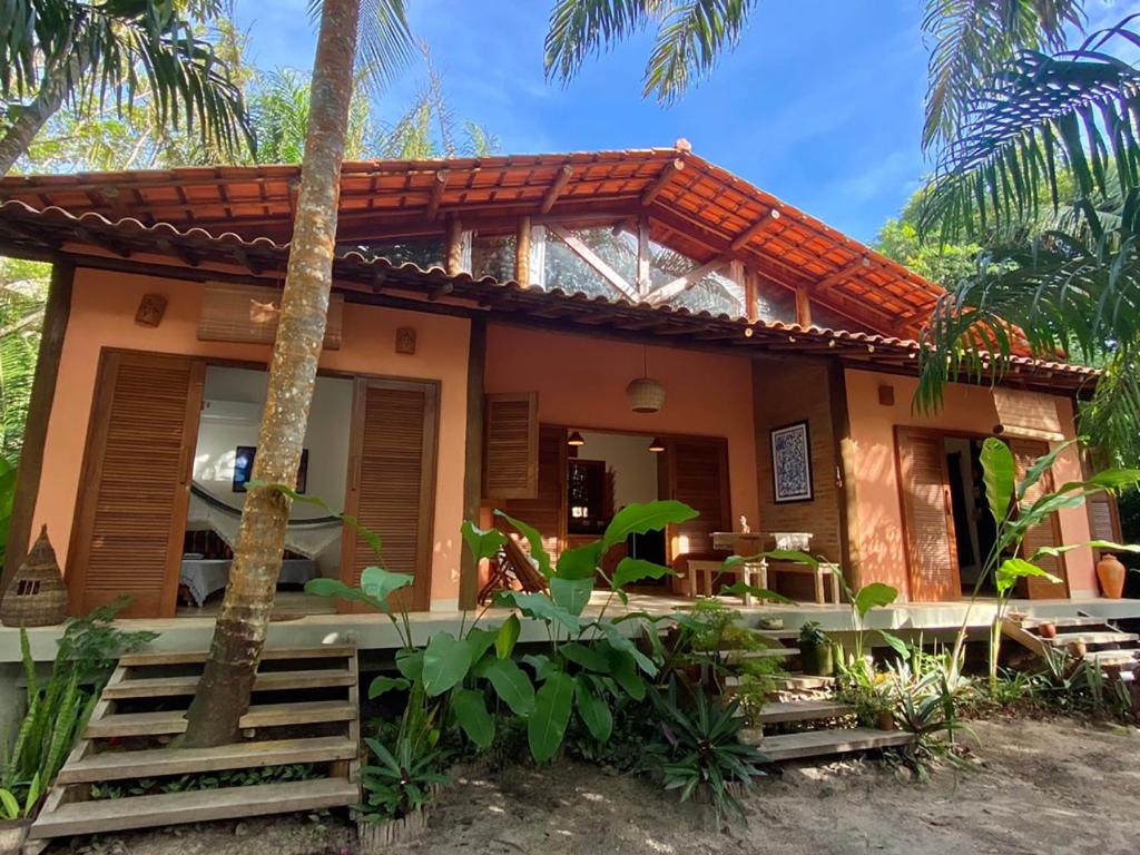 a house on the beach with palm trees at Vila Pitanga - Arandis in Marau