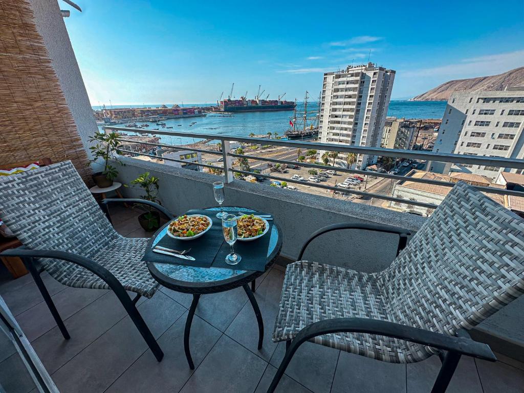 a balcony with a table and chairs with food on it at Departamento esmeralda Iquique x dia in Iquique
