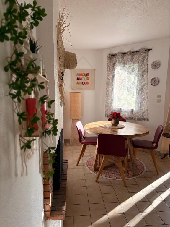 un salon avec une table et des chaises et une fenêtre dans l'établissement cottage cosy du golf avec piscine, à Ploemel