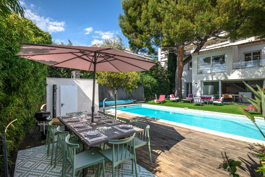 - une table avec un parasol à côté de la piscine dans l'établissement Splendide villa/piscine vue mer, à Nice