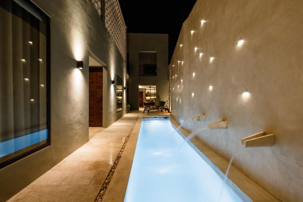 una piscina en un edificio con luces en la pared en Casa Naran centro Mérida, en Mérida