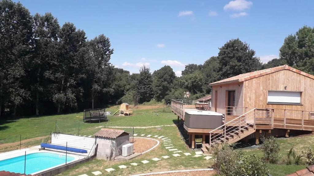 ein Haus mit einem Pool und einem Gebäude in der Unterkunft Charmante maison avec piscine à Chalandray, 25 m² in Chalandray