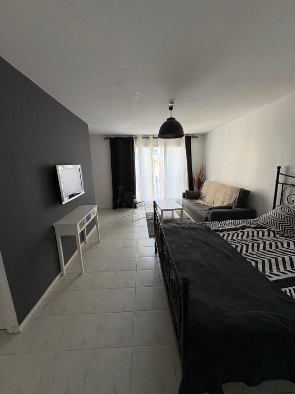 une chambre avec un lit et un salon dans l'établissement Appartement bord de mer, à Nice