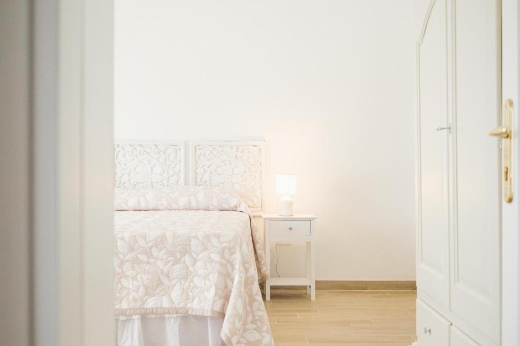 a white bedroom with a bed and a white cabinet at Domus Ilex in San Pantaleo