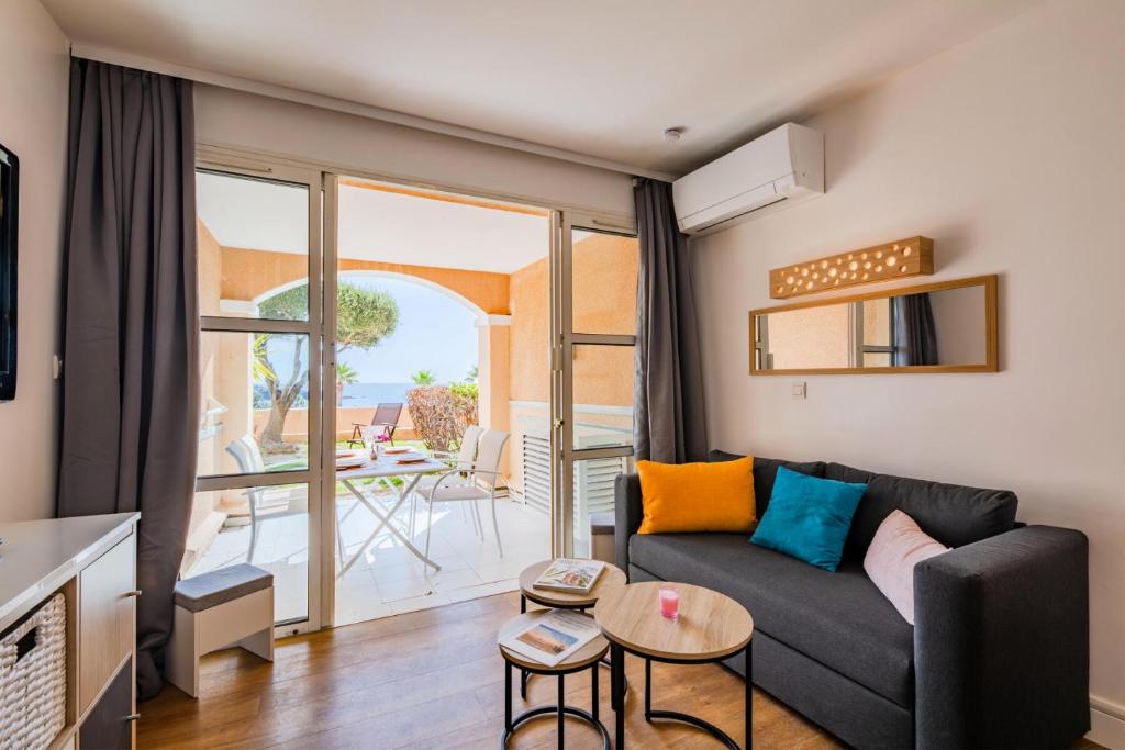 d'un salon avec un canapé et un balcon. dans l'établissement Résidence le Village de Cap Esterel - maeva Home - Appartement vue mer 2 pièces 4 personnes - Prestige - super Home MAE-2171, à Saint-Raphaël