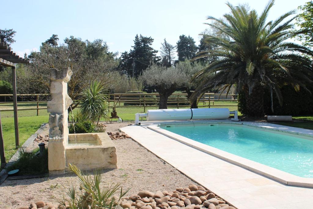 - une piscine dans une cour avec une fontaine dans l'établissement Le Mas des Fontaines, à Châteaurenard