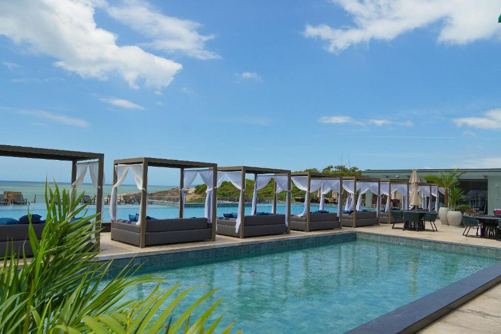 イタペマにあるSuíte com vista para montanhas no Blue Sea Hotel, beira-mar+lazer completoのラウンジチェアと海のあるプール