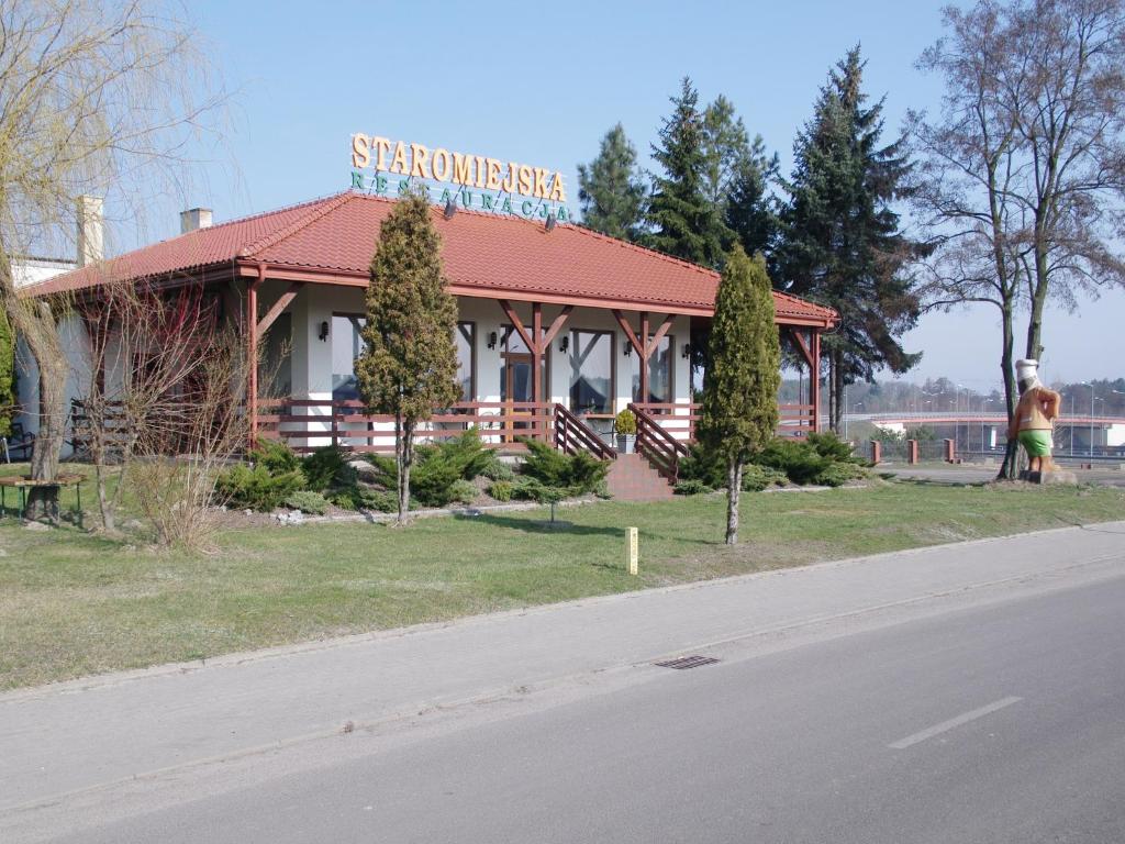 a building with a sign on it on the side of a road at Pokoje Gościnne in Stare Miasto