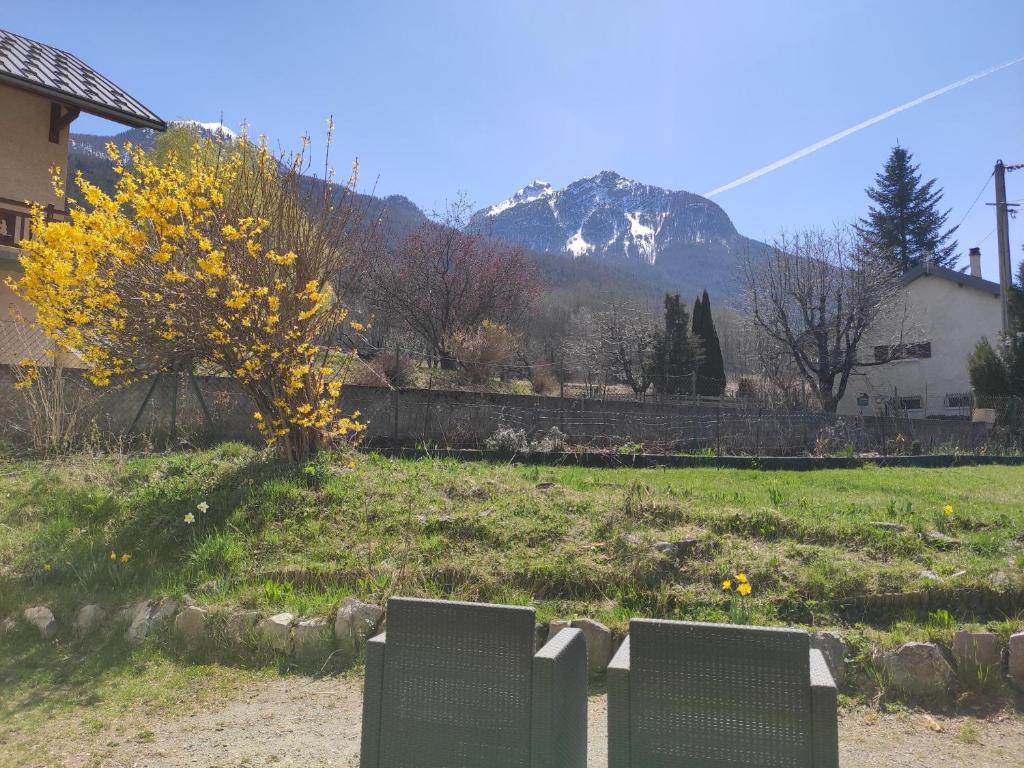 deux chaises dans un champ avec une montagne en arrière-plan dans l'établissement NEW - Jardin - Proche Briançon Serre Che - Vue montagne - Ski, à Villar-Saint-Pancrace