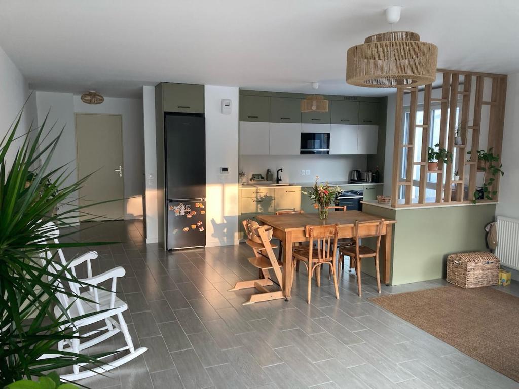 une cuisine et une salle à manger avec une table et des chaises en bois dans l'établissement Appartement familial T4 Bayonne, à Bayonne