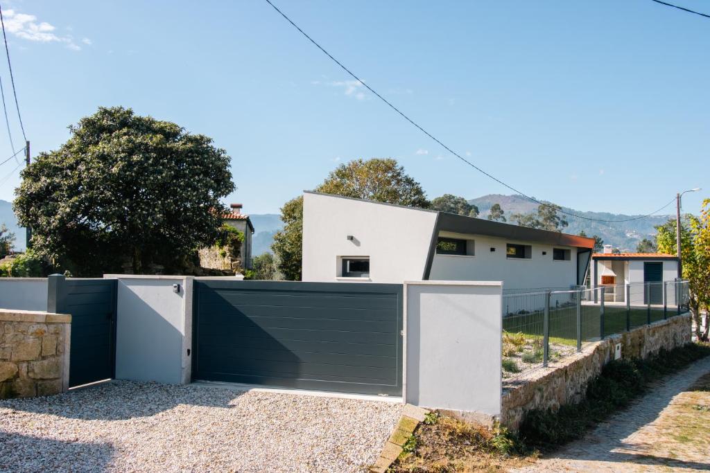 a house with a green garage door at Casa da Tininha in Couto