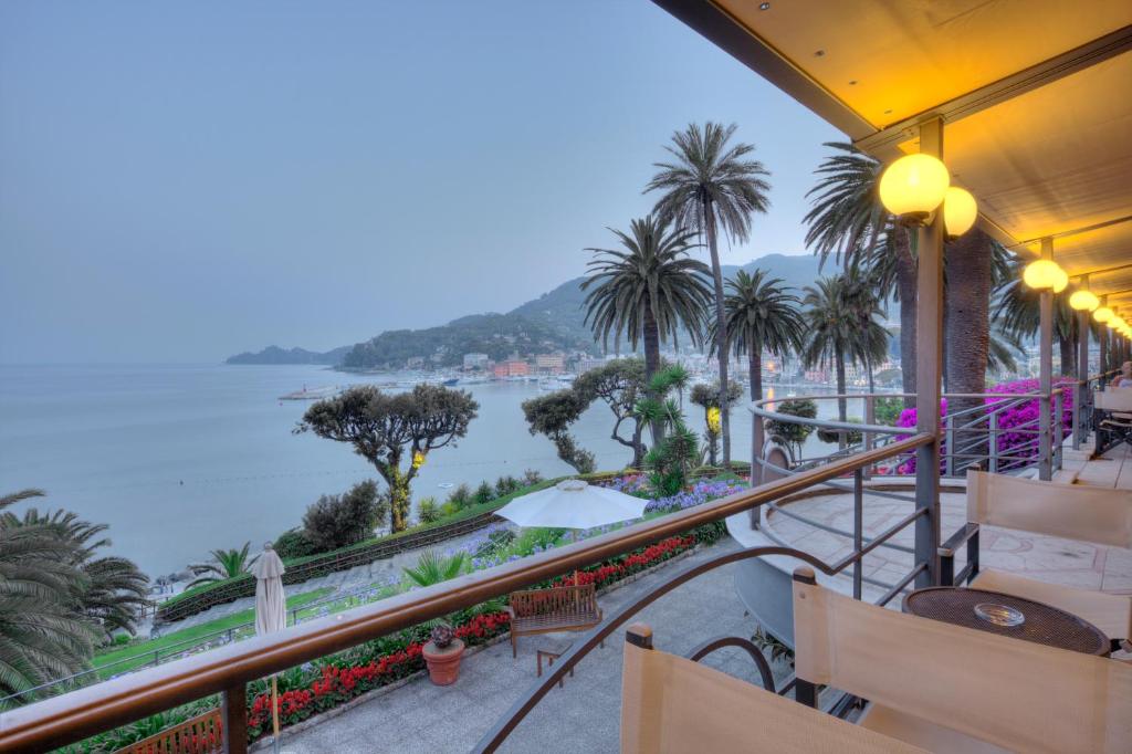 a balcony with a view of the water and palm trees at Hotel Continental in Santa Margherita Ligure