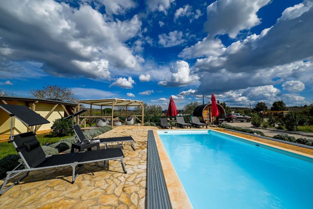 a swimming pool with lounge chairs and a house at Bella di Campo in Rovinj
