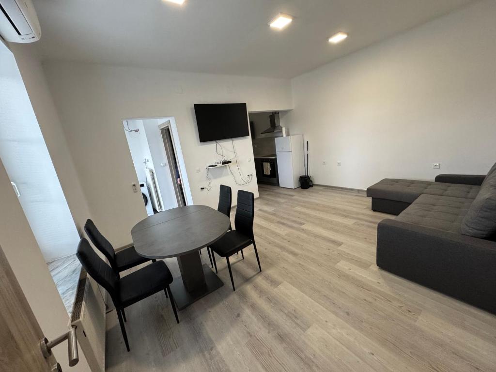 Una sala de estar con una mesa y sillas y un sofá. en Jack apartments, en Maribor