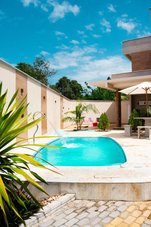 a swimming pool in front of a house at Casa juçara lençóis in Barreirinhas