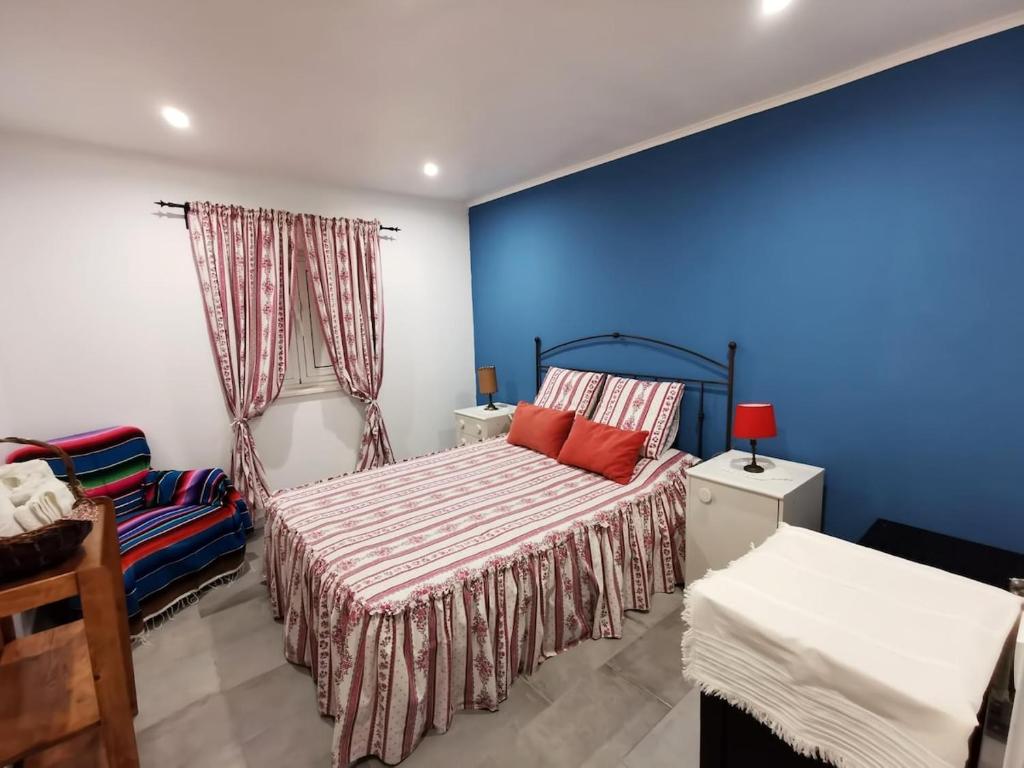 a bedroom with a bed and a blue wall at Quinta das Lameiras in Sao Pedro de Tomar