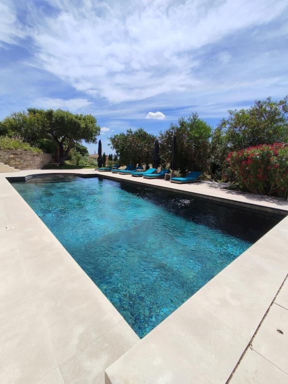 une piscine avec de l'eau bleue dans une cour dans l'établissement Villa MagnifiK I Luxe I Pool I Sea View I Clim, à Grimaud