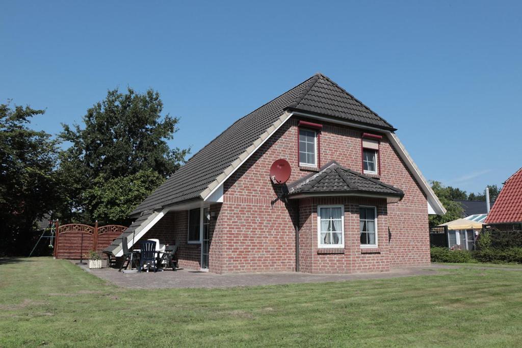 a red brick house with a black roof at Ferienhaus Fischotter - 300m zum Wattenmeer - All Inklusive in Otterndorf