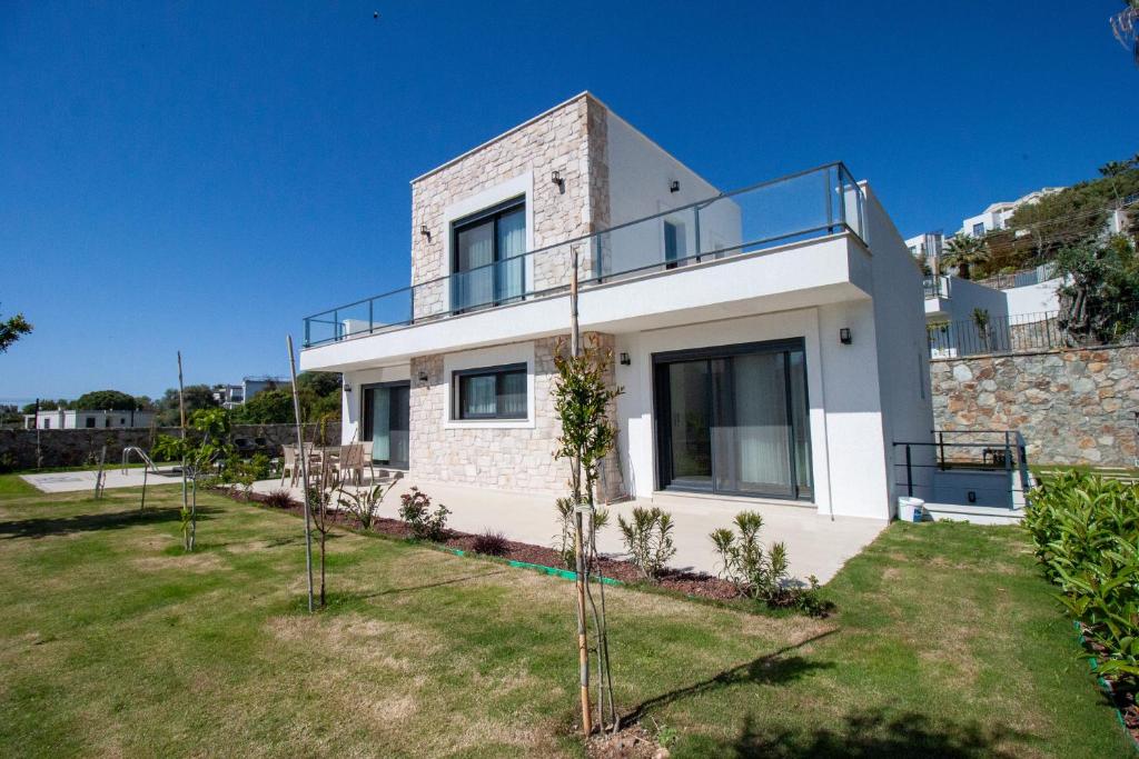 een wit huis met een balkon erbovenop bij Villa Casa Luz 2 in Bodrum City