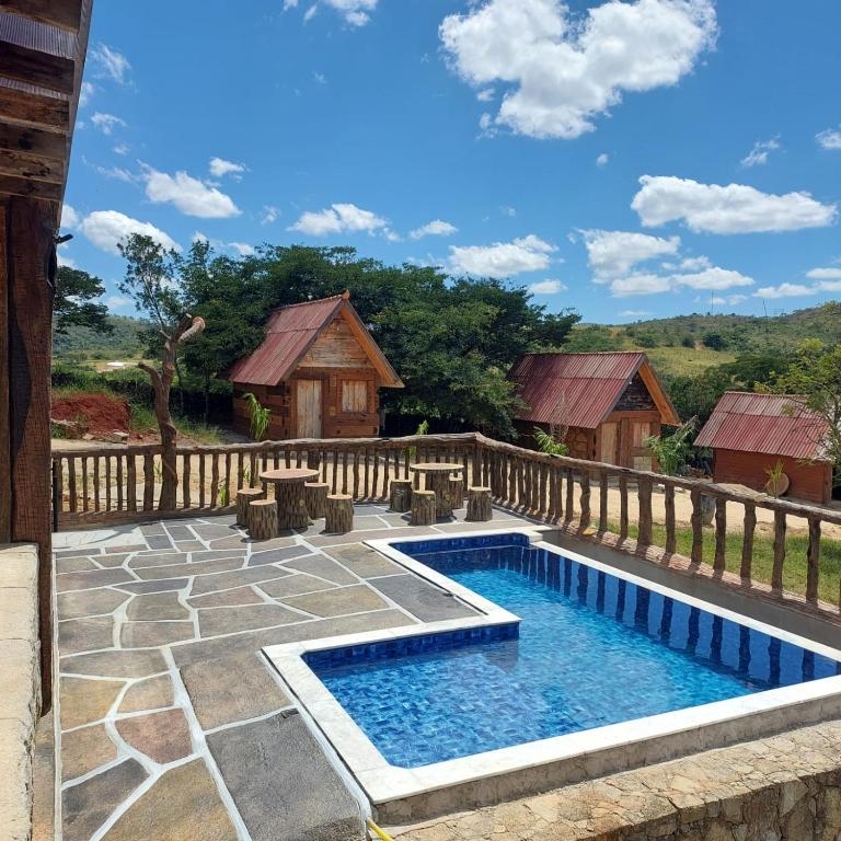 a swimming pool in a yard with a wooden fence at Chale do guerreiro in Coroas