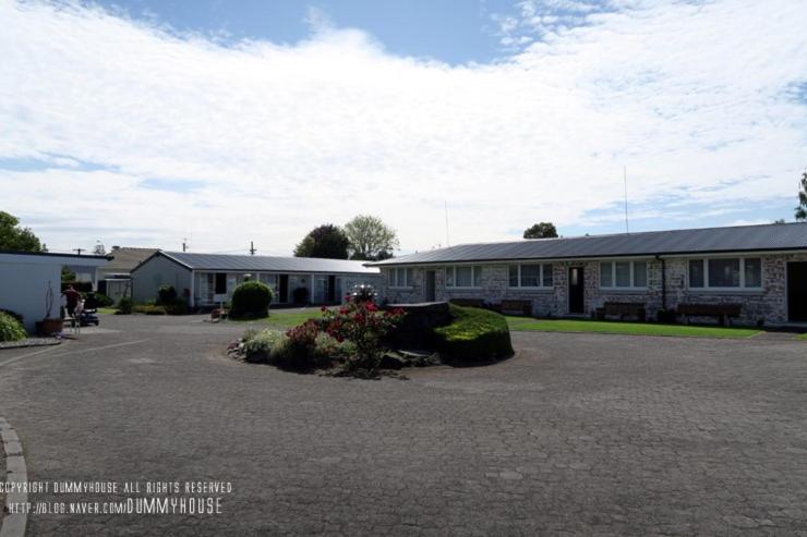 タウランガにあるGarden Court Motel & Backpackersの前に駐車場がある建物